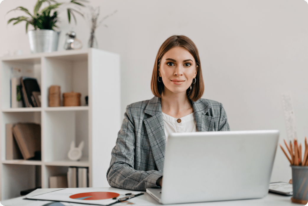 business-woman-checkered-jacket-with-smile-while-sitting-desk-her-office 1-min